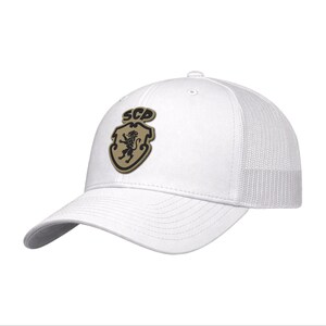 May include: A white baseball cap with a mesh back and a curved brim. The front panel features a tan shield-shaped patch with a black lion emblem and the letters SCP printed in black at the top of the shield, centered on the cap's front.