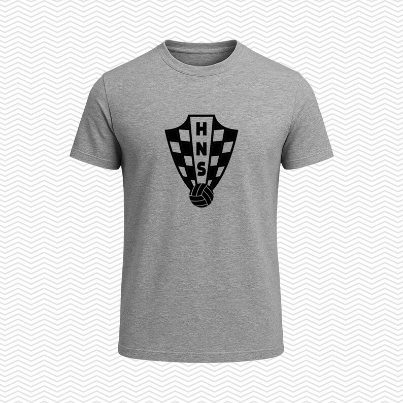 May include: A heather gray short-sleeved t-shirt featuring a black graphic on the chest. The graphic displays a shield shape with a checkered pattern, the letters HNS stacked vertically in the center, and a small soccer ball icon at the bottom.