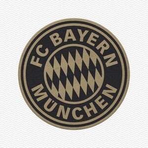 May include: A circular emblem featuring the FC Bayern Munchen logo in a black and tan color scheme. The center displays a diamond-patterned design, surrounded by a circular border containing the text FC BAYERN MUNCHEN in bold lettering.