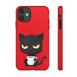 May include: A red phone case featuring a cartoon black cat with an angry expression, holding a white coffee mug. The case has a black border and a side view showing the red color.
