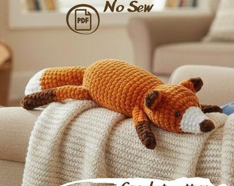 May include: A crochet fox toy with orange, white, and dark brown yarn. The fox has a white-tipped tail, dark brown paws, and a white muzzle. Text above reads Baby Fox No Sew PDF, and text below reads Crochet pattern in a white brush stroke.