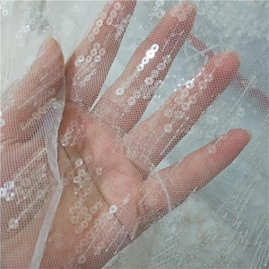 May include: A white ceramic mug with a black handle and the text "But First, Coffee" in a black, bold font. The mug is sitting on a wooden surface. The mug is approximately 4 inches tall.