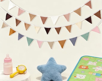 May include: A nursery scene with a baby bottle, a yellow rattle, a blue star-shaped plush, and a green play mat with animal illustrations. Three rows of colorful triangle flags hang above.