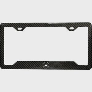 May include: Black carbon fiber license plate frame with the Mercedes-Benz logo. The frame has a woven texture and a rectangular shape with rounded corners. The Mercedes-Benz logo is white.