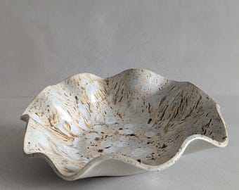 Handgemaakte decoratieve schaal van organisch keramiek, beige glazuur met witte en bruine accenten, hoogwaardig steengoed, uniek stuk.