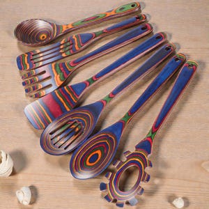 7 piece wooden spoon and spatula set displayed on kitchen counter, crafted from durable Pakkawood with rich natural grain, ideal for modern farmhouse kitchens, eco-friendly home decor lovers, and stylish cooking spaces focused on warmth and functionality.