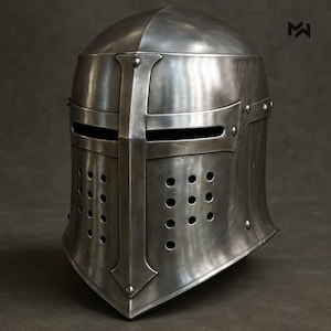 May include: A silver-colored medieval helmet with a cross design on the front. The helmet has a rounded top, eye slits, and numerous small ventilation holes. Rivets secure the metal plates. The overall design suggests historical armor.