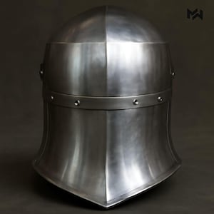 May include: A polished steel medieval helmet with a rounded top and a flared lower section. The helmet features a horizontal band with rivets and a pointed lower edge. The metal has a reflective surface.
