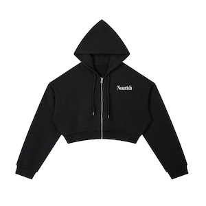 May include: Black cropped hoodie with a drawstring hood and a full-length zipper. The word "Nourish" is printed in white on the right chest area. The hoodie has long sleeves and a cropped waist.