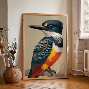 Puede incluir: Un cuadro enmarcado con una ilustración detallada de un martín pescador. El ave tiene la cabeza azul, pico negro y plumas en tonos azules, naranjas y blancos. La obra de arte está sobre un fondo neutro y enmarcada en madera natural.