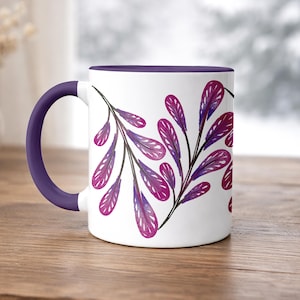 Puede incluir: Una taza de cerámica blanca con un asa negra y el texto "But First, Coffee" en negro, en negrita. La taza está sobre una superficie blanca.