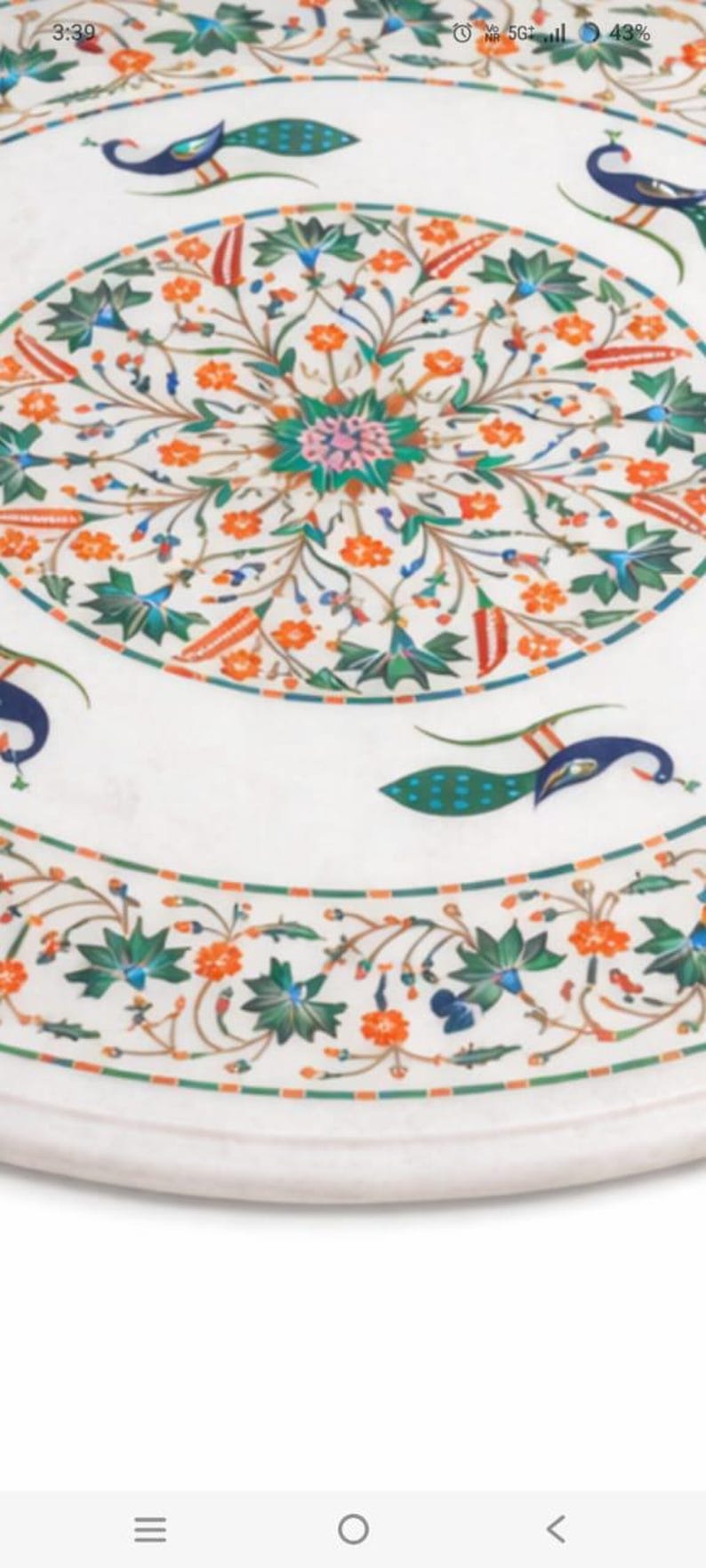 K&ouml;nnte beinhalten: Runder wei&szlig;er Marmortisch mit aufwendigem Blumen- und Pfauenfedern-Inlay. Das Design enth&auml;lt orange, gr&uuml;ne, blaue und rosa Akzente. Der Tisch hat einen dekorativen Rand und misst etwa 100 cm im Durchmesser.
