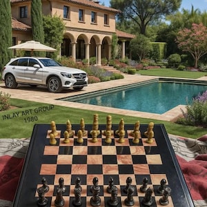 Puede incluir: Un juego de ajedrez de lujo con piezas negras y doradas sobre un tablero a cuadros. El tablero está montado al aire libre con un SUV blanco, una casa grande y una piscina en el fondo. El texto "INLAY ART GROUP 1980" es visible.