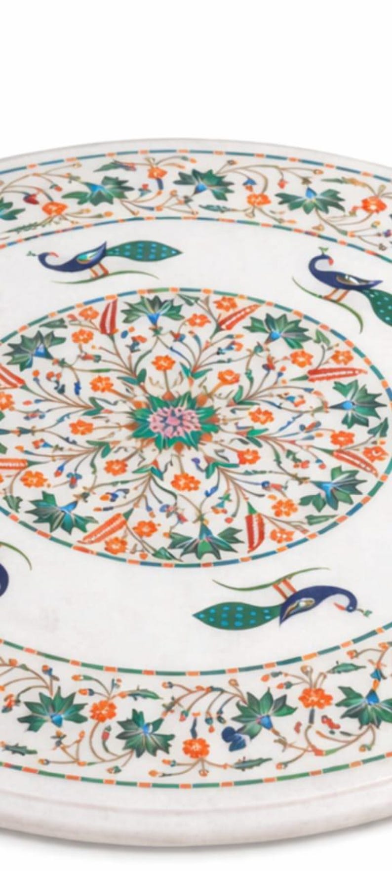 K&ouml;nnte beinhalten: Runde Tischplatte aus wei&szlig;em Marmor mit aufwendigem Blumen- und Pfauenmuster. Das Design weist orange, gr&uuml;ne, blaue und rote Akzente auf. Der Tisch hat eine kreisf&ouml;rmige Form.