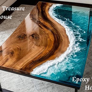 May include: Rectangular coffee table with a unique design. The table features a wooden surface on one side and a blue epoxy resin design resembling ocean waves on the other. The table has a black metal frame.