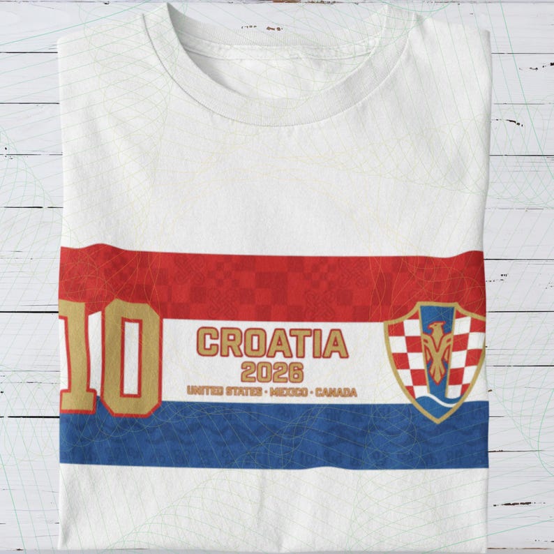 May include: White t-shirt with a Croatian flag design. The shirt features a red and white stripe across the chest, the number 10 in gold, and the text "CROATIA 2026". A Croatian coat of arms is on the right side.
