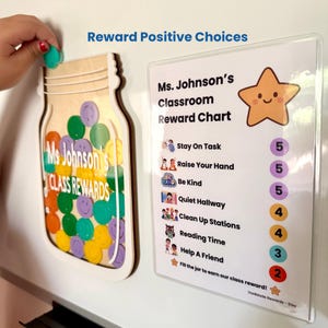 May include: A wooden jar-shaped reward tracker with colorful smiley face tokens and a matching classroom reward chart. The chart lists tasks like Stay On Task and Be Kind with corresponding point values, topped with a smiling star graphic.