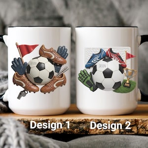 Puede incluir: Tazas de cerámica blanca con asas y bordes negros, con diseños de fútbol. Una taza muestra un balón de fútbol, botas, guantes y una bandera. La otra taza muestra un balón de fútbol, botas, guantes, un trofeo y una red.