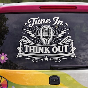 May include: A vehicle's rear window features a white graphic with the words "Tune In" above a vintage microphone illustration. Below the microphone, a banner reads "Think Out." A rainbow sticker and flower stickers add color.
