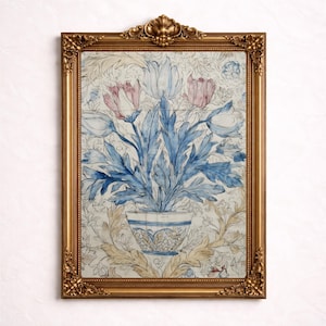 Puede incluir: Impresión floral enmarcada en un marco dorado ornamentado. La imagen muestra un jarrón con flores azules y rosas con grandes hojas azules sobre un fondo crema con un patrón floral. El marco es ricamente decorado.
