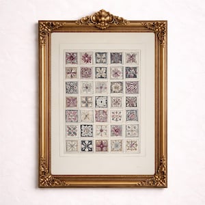 May include: A framed print featuring a grid of floral designs in a variety of colors, including pink, purple, and gray. The print is set within a gold-colored ornate frame, adding a touch of elegance to the artwork.