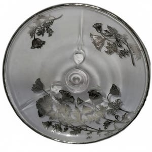 May include: A clear glass serving dish with a silver rim and floral design. The dish is divided into three sections and features etched flowers and leaves. The design is repeated around the edge of the dish.