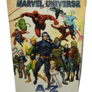 May include: A hardcover book titled "Marvel Official Handbook of the Marvel Universe." The cover features various Marvel comic book characters in action poses. The book's spine shows the letters "A-Z".