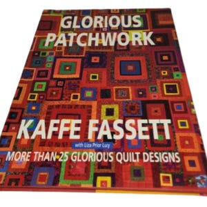 May include: A hardcover book titled "Glorious Patchwork" by Kaffe Fassett. The cover features a colorful patchwork design with squares in various colors. The text "MORE THAN 25 GLORIOUS QUILT DESIGNS" is also visible.