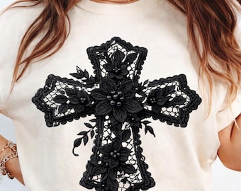 May include: Cream-colored t-shirt featuring a large, ornate black cross design. The cross is embellished with floral and leaf details, creating a textured, three-dimensional effect. The design is centered on the shirt.