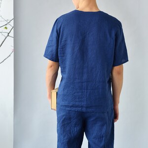 Pode incluir: Um conjunto de pijama de linho azul marinho com uma parte superior de manga curta e cal&ccedil;&otilde;es. O conjunto &eacute; feito de um tecido leve e respir&aacute;vel, perfeito para o clima quente.