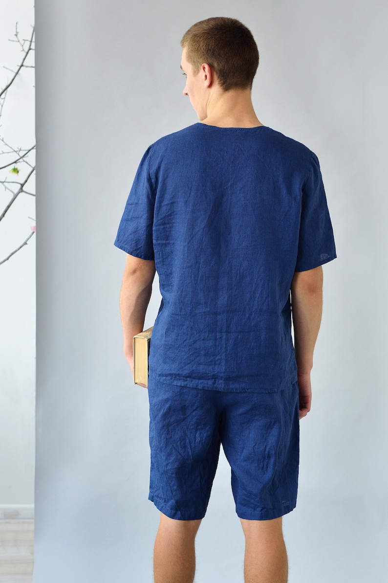 Pode incluir: Um conjunto de pijama de linho azul marinho com uma parte superior de manga curta e cal&ccedil;&otilde;es. O conjunto &eacute; feito de um tecido leve e respir&aacute;vel, perfeito para o clima quente.