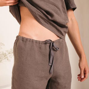 May include: A pair of brown linen shorts with a drawstring waist. The shorts are made of a lightweight, breathable fabric and are perfect for warm weather.