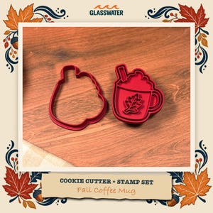 May include: A red plastic cookie cutter and stamp set in the shape of a coffee mug with a leaf design. The set includes a separate outline cutter and a detailed stamp piece featuring a mug with whipped cream and a leaf emblem.
