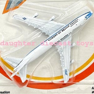 May include: A packaged die-cast metal Dynaflites toy set. The packaging features a silver jet and a white passenger plane. The background is orange and yellow. The text on the package reads 'For ages over 3'.