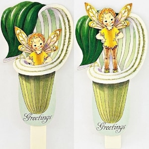 May include: Two vintage paper fairy greeting cards. Each card features a fairy in a yellow outfit with golden wings, nestled within a stylized green and white flower. The word "Greetings" is written in script at the bottom of each card.