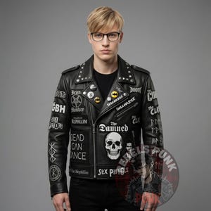 May include: Black leather jacket adorned with patches displaying band names and symbols. The jacket features silver studs on the shoulders and lapels. Patches include "Sex Pistols", "The Damned", and "Discharge".