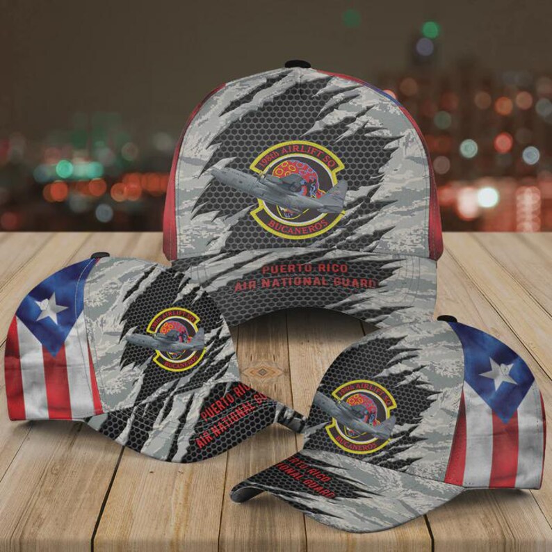May include: Three baseball caps with a camouflage pattern and the Puerto Rican flag. Each cap features a patch with an airplane and the text "156th Airlift Sq. Bucaneros" and "Puerto Rico Air National Guard."