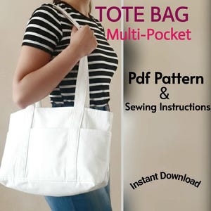 Może przedstawiać: Biała torba typu tote z wieloma kieszeniami jest trzymana przez osobę w czarno-białej koszulce w paski. Torba ma dwa uchwyty i kilka zewnętrznych kieszeni. Tekst na zdjęciu brzmi "TOTE BAG Multi-Pocket Pdf Pattern & Sewing Instructions Instant Download."