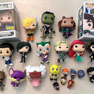 May include: A collection of various vinyl figures and keychains, including two boxed Funko Pop figures labeled Fallout 98 Charisma and Demon Slayer 867 Tanjiro Kamado, alongside numerous loose character figures featuring diverse colors and designs.