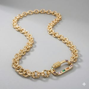 May include: Gold-toned necklace with a textured chain design. The necklace features a decorative clasp with colorful rectangular gemstones. The chain is made of interlocking circular links.