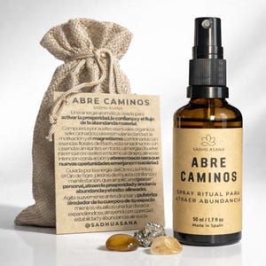 Puede incluir: Una botella de vidrio marrón con un pulverizador negro, etiquetada "ABRE CAMINOS" y "SPRAY RITUAL PARA ATRAER ABUNDANCIA." Una bolsa beige con cordón y una etiqueta con texto están junto a la botella. Contiene 50 ml.