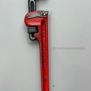 May include: A red 14-inch pipe wrench with a black adjustable jaw. The wrench has the text "THE RIDGE TOOL CO. ELYRIA, OHIO, U.S.A." and the Instagram handle "@moabmavericktools" on the handle.