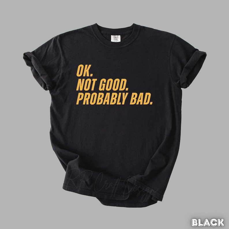Pu&ograve; includere: T-shirt nero con la scritta gialla "OK. NOT GOOD. PROBABLY BAD.". La maglietta ha maniche corte e girocollo. Il testo &egrave; centrato sul davanti.