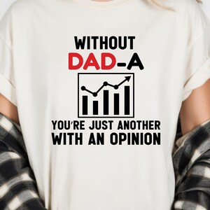 May include: Cream-colored t-shirt with the text "WITHOUT DAD-A" in black and red, and "YOU'RE JUST ANOTHER WITH AN OPINION" in black. A black and white graphic of a chart is in the center.