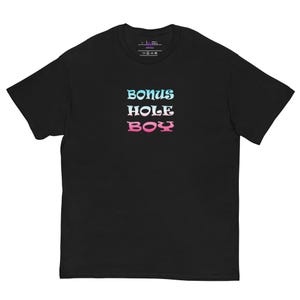 Peut inclure: T-shirt noir avec l'inscription "BONUS HOLE BOY" en dégradé bleu et rose. Le t-shirt a un col rond et des manches courtes. Le texte est centré sur le devant du vêtement.