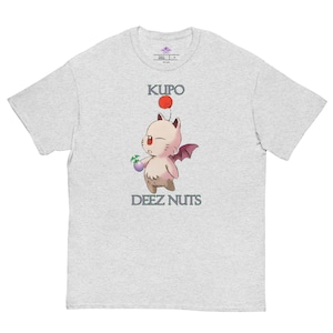 May include: Light gray t-shirt featuring a cartoon character with a red pom-pom, holding a purple object, and small wings. The text "KUPO" is above the character, and "DEEZ NUTS" is below.