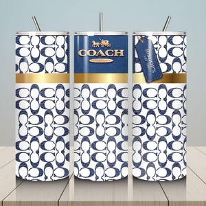 May include: Three cylindrical tumblers with straws featuring a white and navy blue repeating logo pattern. The center tumbler displays the gold COACH NEW YORK logo and a carriage icon. A blue leather-style tag reads BISHOP'S EST 1941.