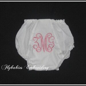 May include: White cotton baby bloomers with a pink embroidered monogram "MG" and lace trim. Flybabies Embroidery.