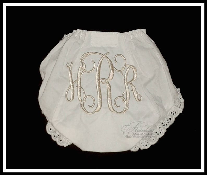 May include: White cotton baby bloomers with a lace trim and a monogrammed "HPR" in a script font.