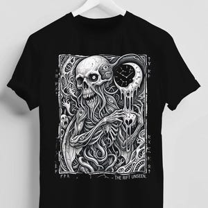 Può includere: T-shirt nera con una grafica in bianco e nero di una figura scheletrica che tiene un orologio che si scioglie. Il design include motivi intricati e il testo "- THE RIFT UNSEEN." La maglietta è appesa a un appendiabiti bianco.